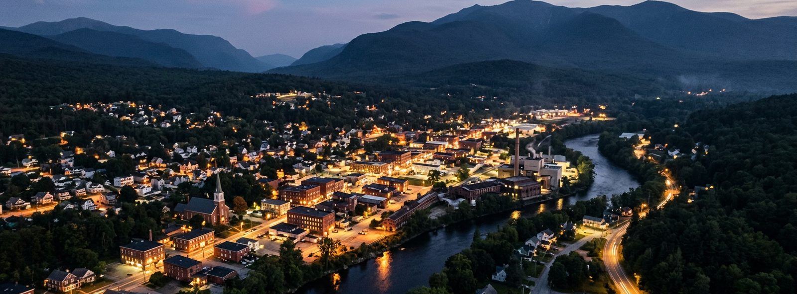 Aerial view of the Berlin, New Hampshire skyline at dusk, illustrating the metro area TactStack serves trade and service businesses in