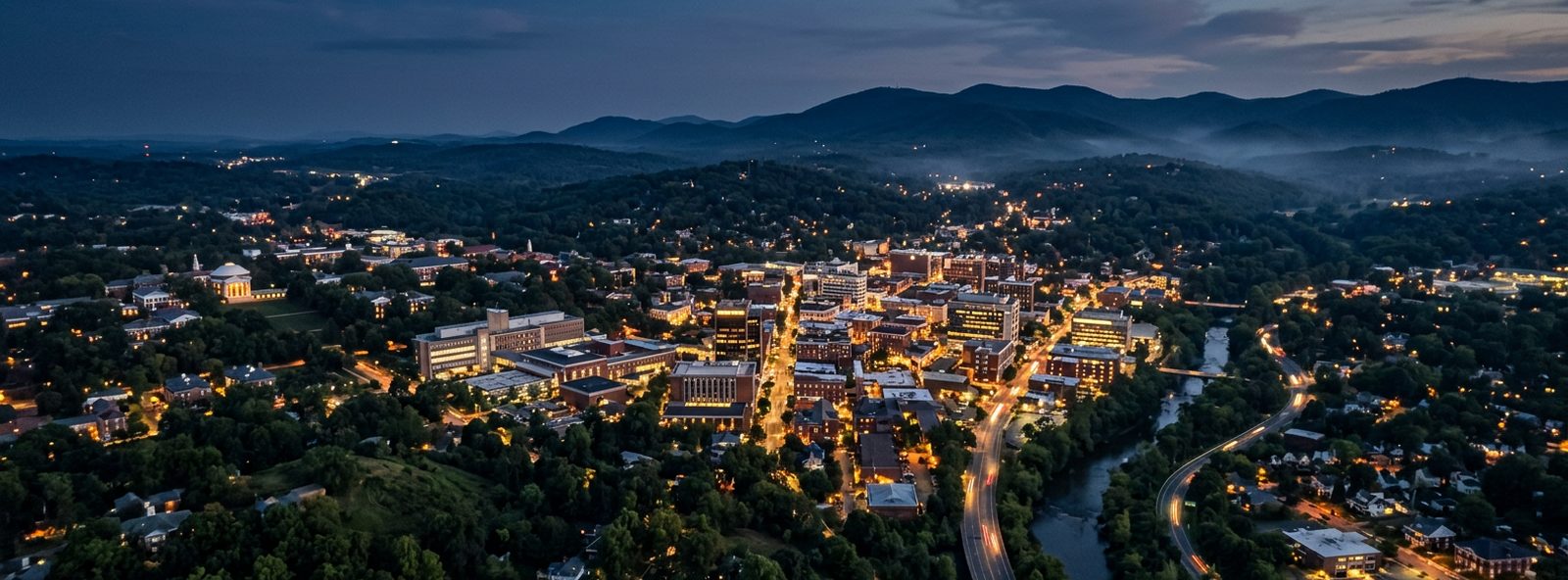 Aerial view of the Charlottesville, Virginia skyline at dusk, illustrating the metro area TactStack serves trade and service businesses in