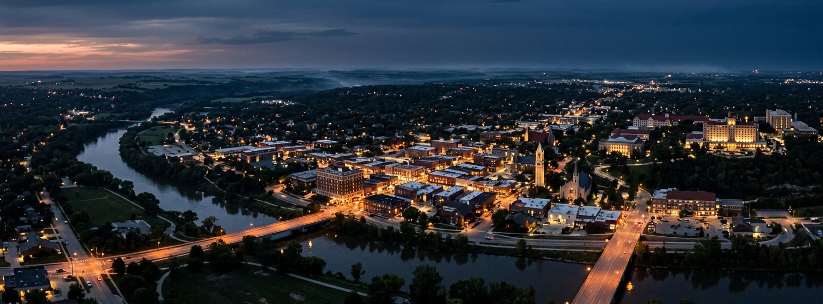Aerial view of the Lawrence, Kansas skyline at dusk, illustrating the metro area TactStack serves trade and service businesses in