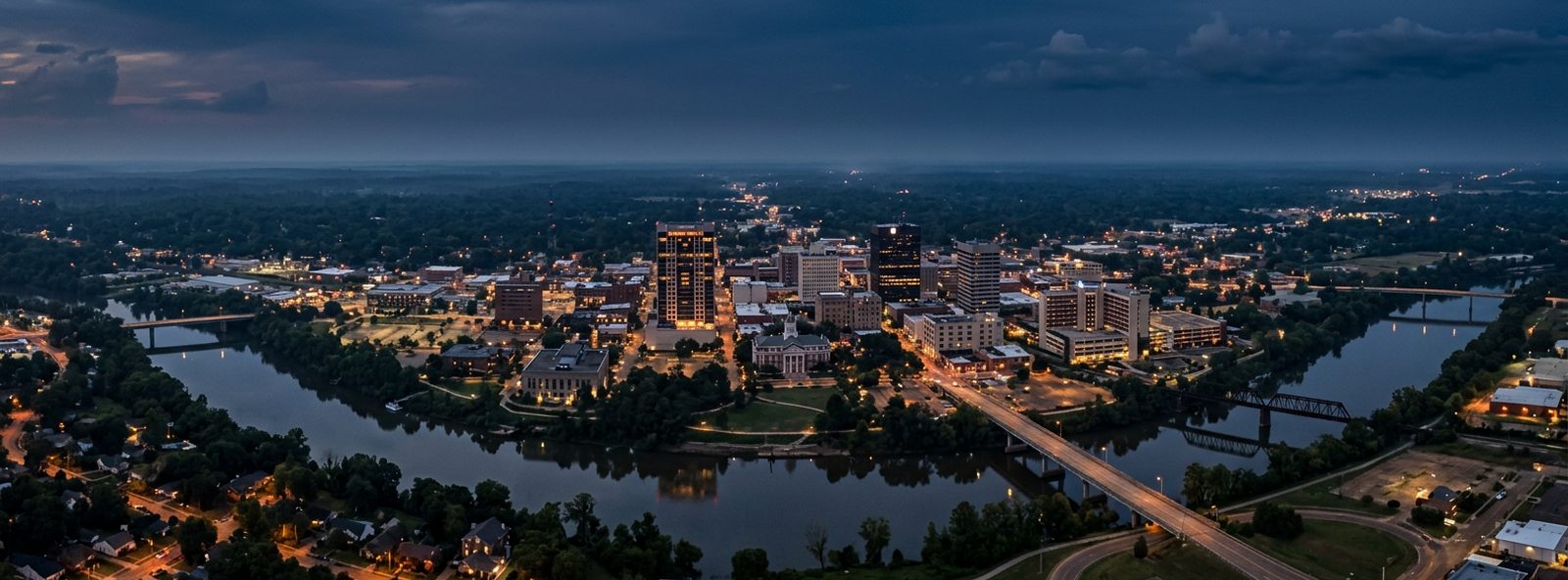 Aerial view of the Monroe, Louisiana skyline at dusk, illustrating the metro area TactStack serves trade and service businesses in