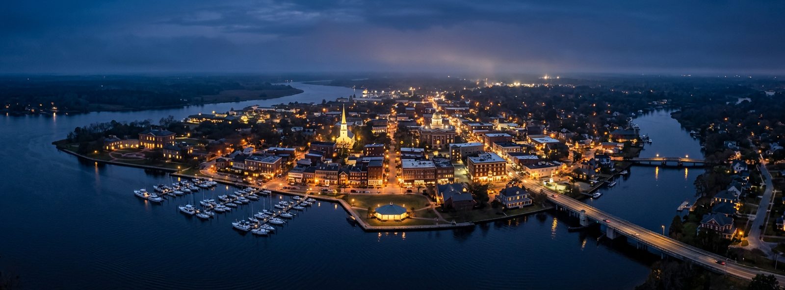 Aerial view of the New Bern, North Carolina skyline at dusk, illustrating the metro area TactStack serves trade and service businesses in
