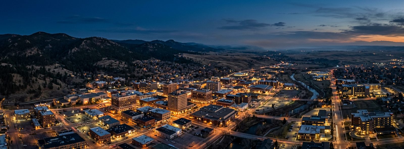 Aerial view of the Rapid City, South Dakota skyline at dusk, illustrating the metro area TactStack serves trade and service businesses in